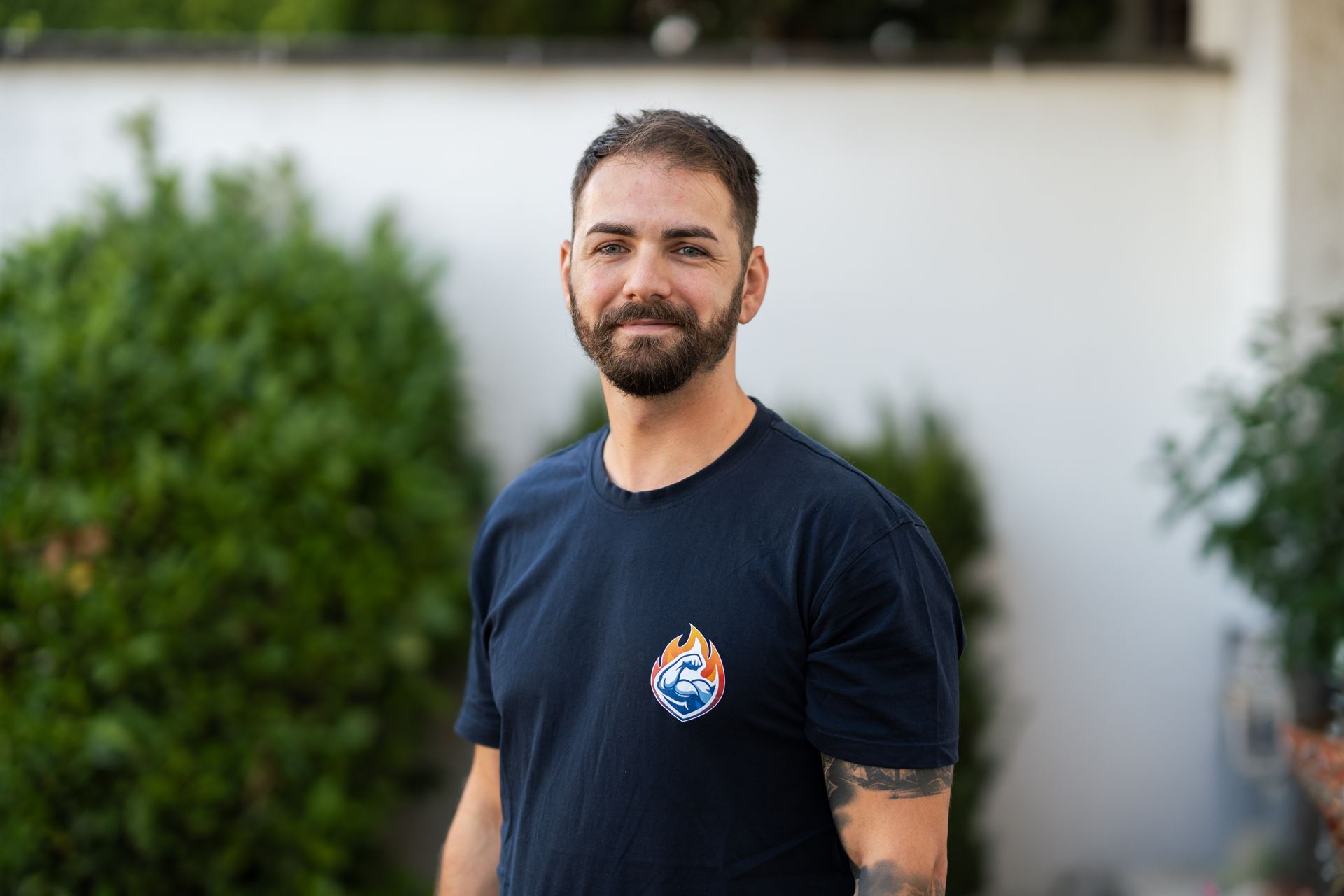 Inhaber von Heizstabil im Firmenshirt, Porträtaufnahme vor grünem Hintergrund